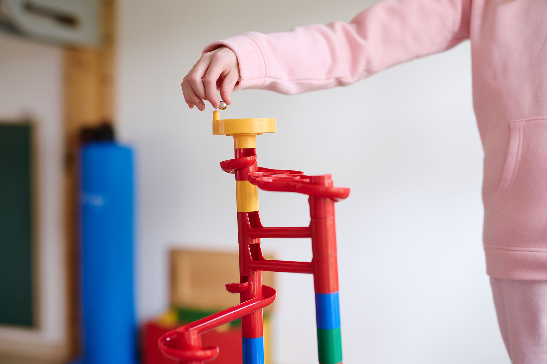 Ein Kind spielt mit einer Murmelbahn.