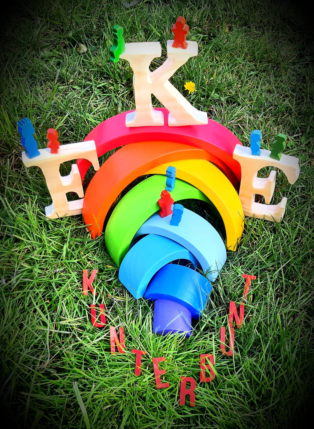 Das Bild zeigt buntes Spielzeug, das auf einer Wiese liegt.