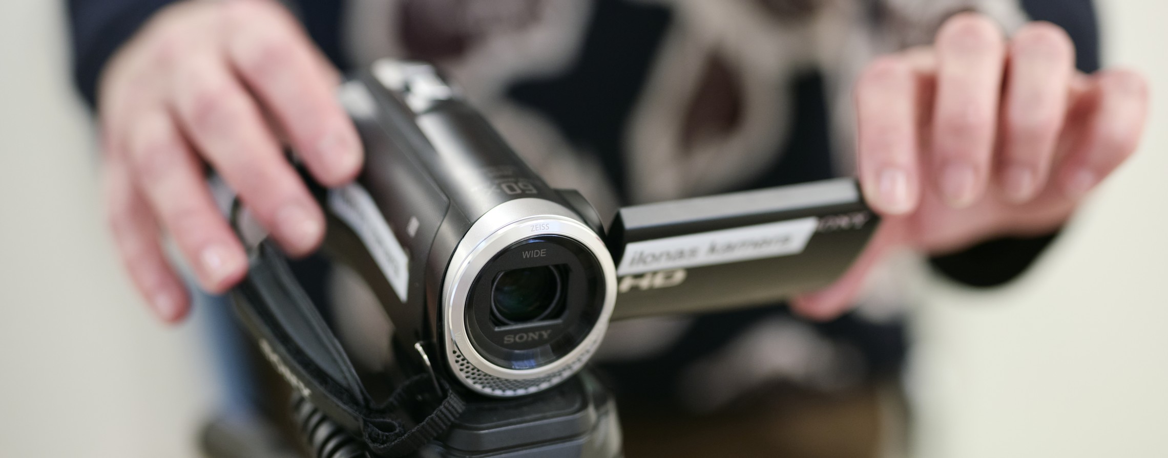 Eine Person hält eine Kamera.