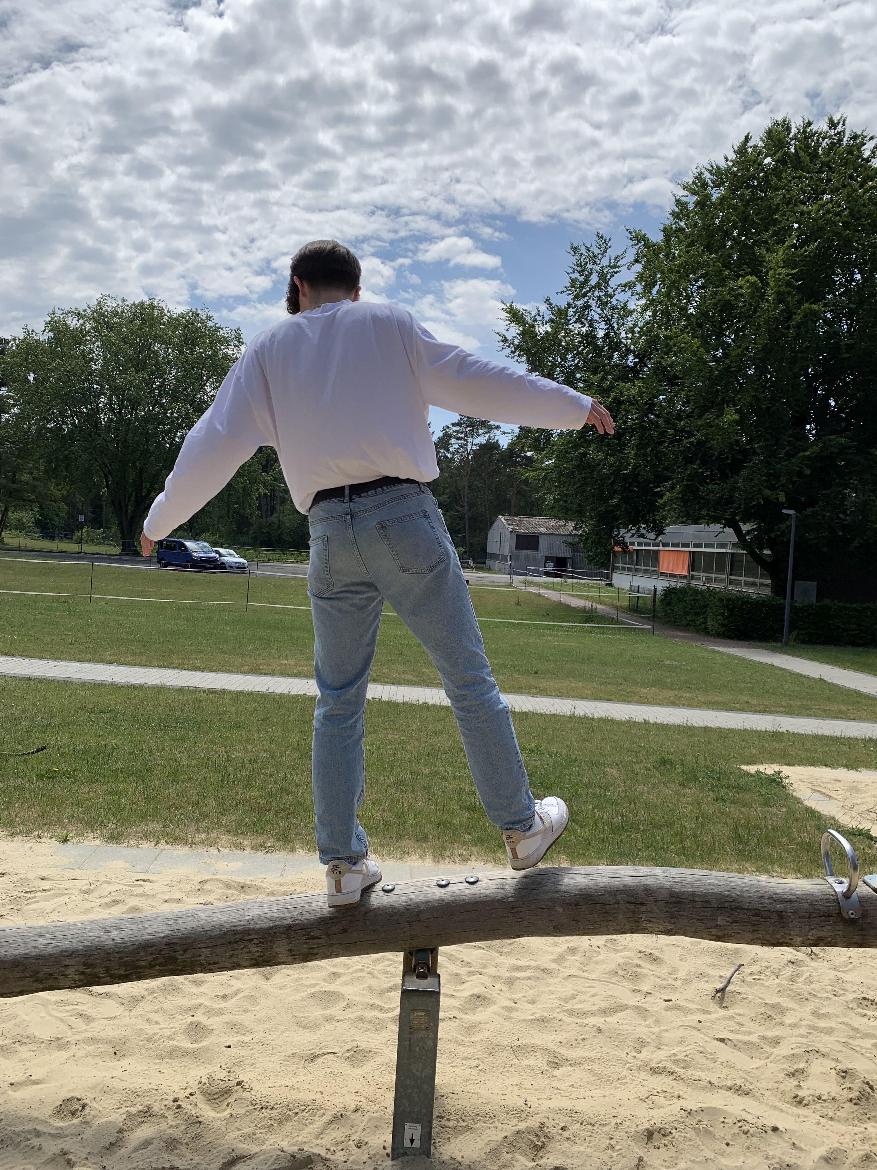 Das Bild zeigt eine Person, die auf einer Wippe balanciert.