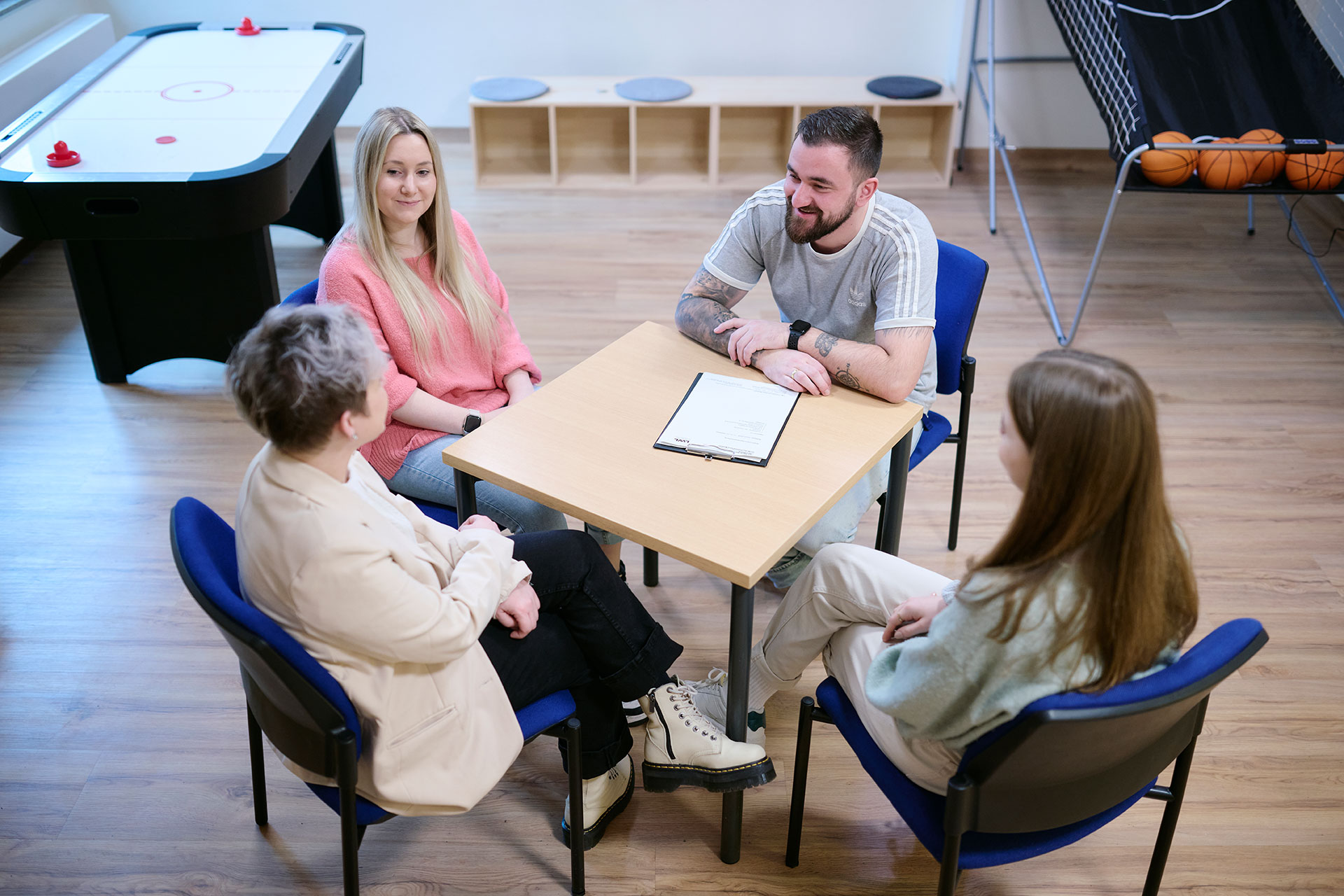 Vier Personen sitzen an einem Tisch und unterhalten sich.
