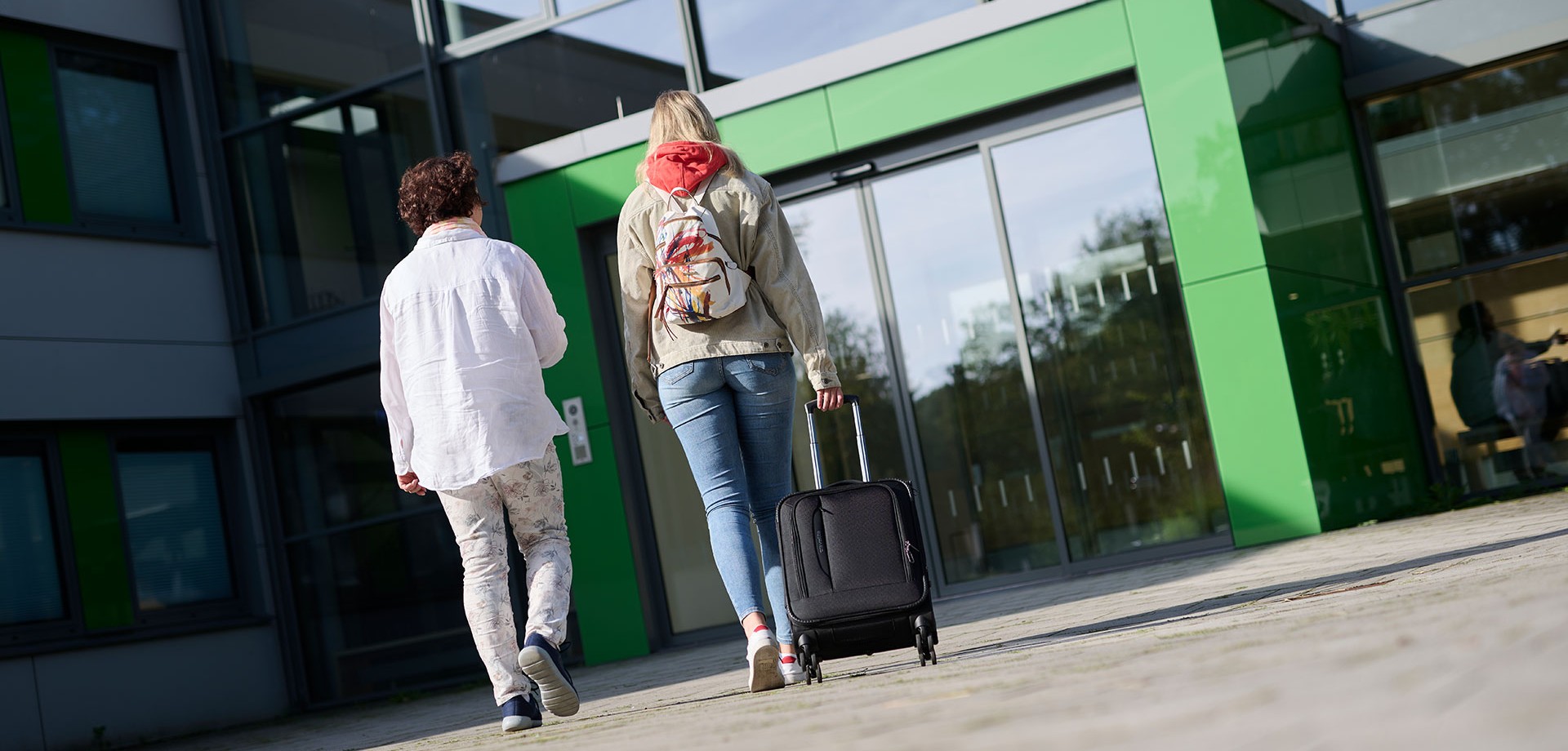 Eine Mutter und ihre Tochter gehen in ein Gebäude