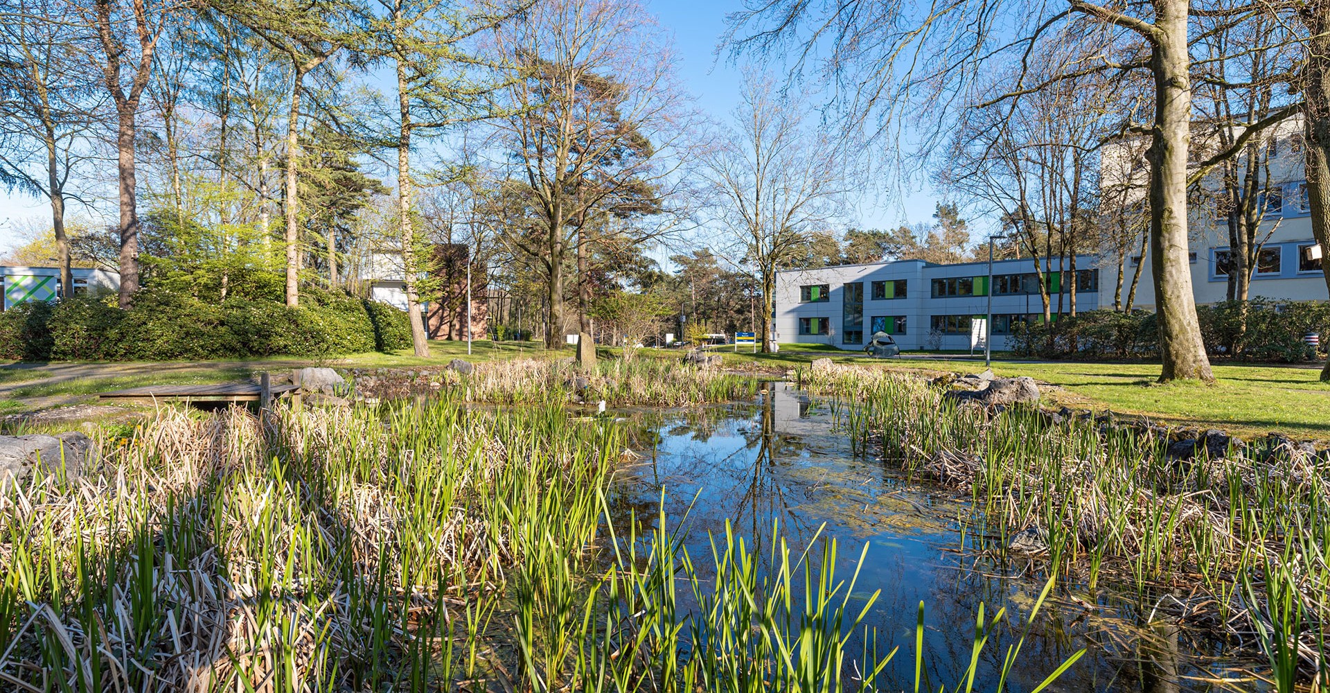 Das Bild zeigt das LWL-Klinikum für Kinder- und Jugendpsychiatrie Marl - Dortmund - Haardklinik von außen. Im Vordergrund ist ein kleiner See zu sehen