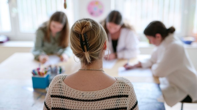 Eine Gruppe sitzt an einem Tisch und arbeitet in der Ergotherapie