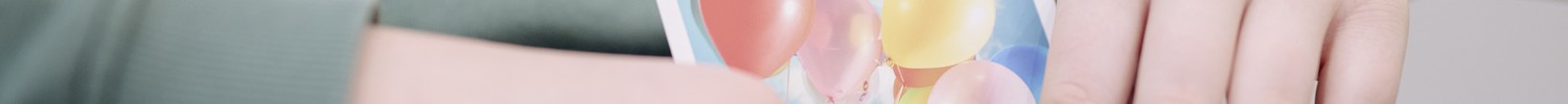 Das Bild zeigt ein Kind, das eine Gefühlskarte mit Luftballons hält.