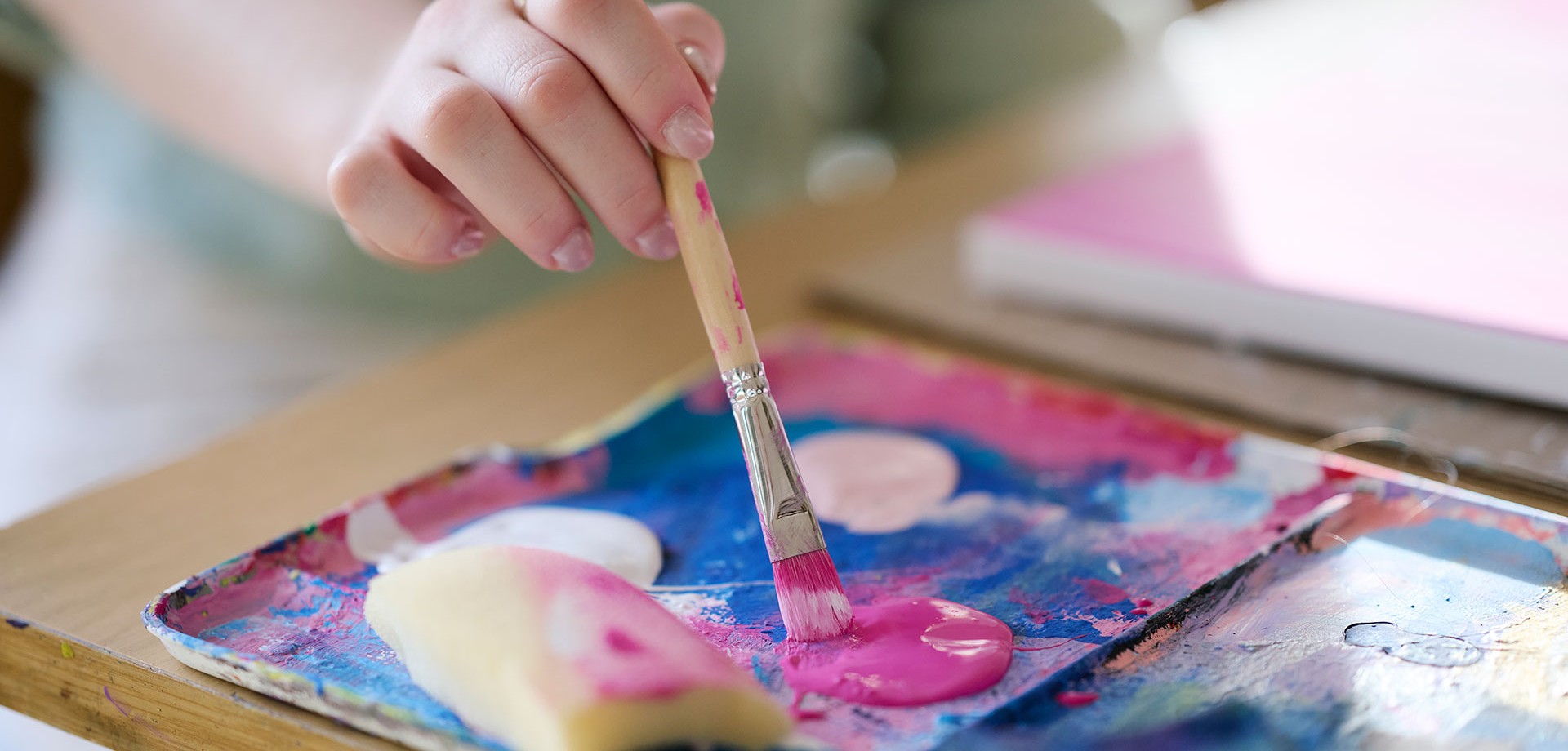 Eine Person malt ein buntes Kunstwerk.