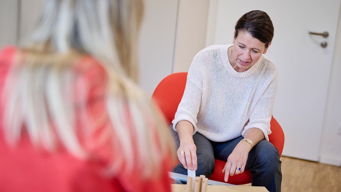 Das Bild zeigt ein Gespräch zwischen einer Therapeutin und einer Patientin.